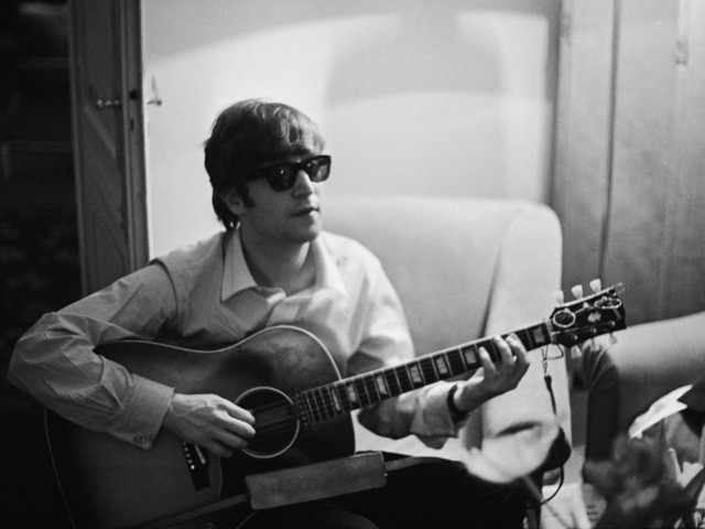 Джон Ленън свири на китара в хотелска стая в Париж, 16 януари 1964 г. Снимка: Getty Images
