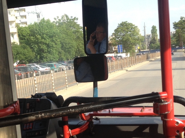 Шофьор на автобус говори по телефон
