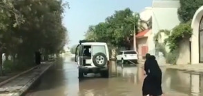 СТРАННА ГЛЕДКА: Жена с бурка сърфира по наводнена улица (ВИДЕО)