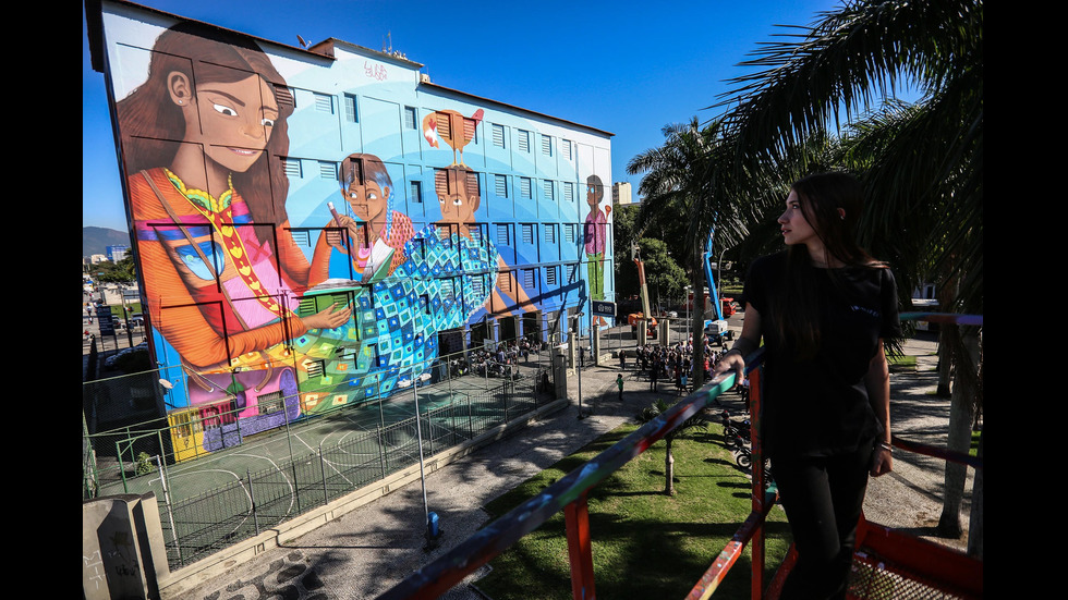 Млада жена нарисува огромен графит в Рио де Жанейро, Бразилия.