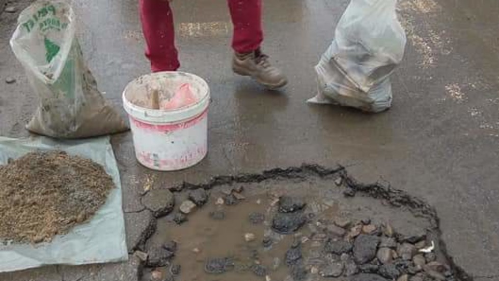 Гражданин сам запълва дупка на пътя